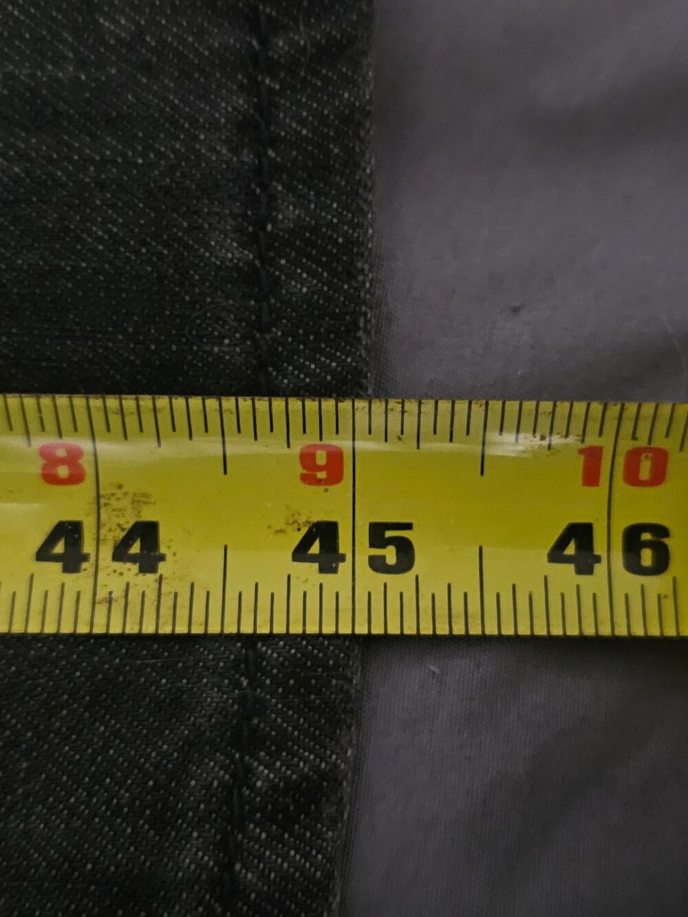Black textured fabric close-up with stitched seam detail